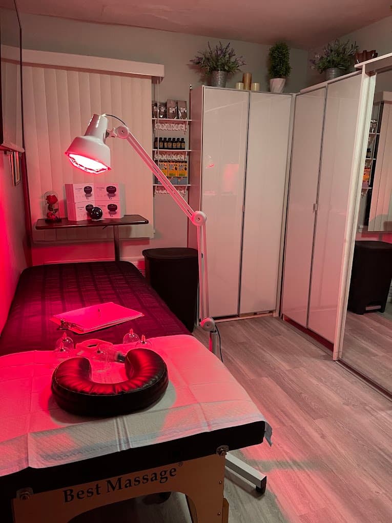 Hijama cupping treatment room in Flushing, Queens, with the red light therapy lamp positioned over the massage table and cupping equipment laid out ready