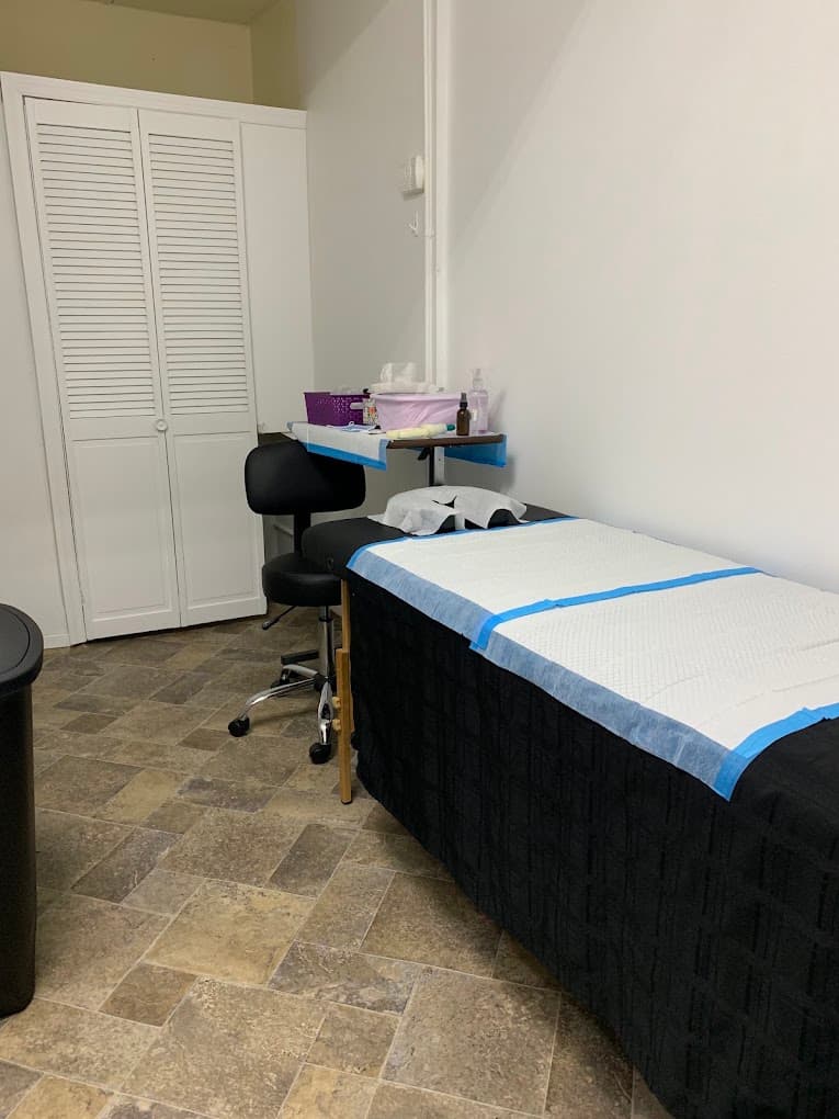 The second treatment room in Flushing, Queens: the couch made up with a fresh disposable cover, a practitioner’s stool and supplies laid out on the side table